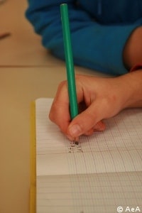 Un enfant écrit sur un cahier